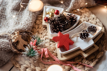 Christmas, New year rustic decorations. Christmas tree shaped plate with pines and red balls, wooden decor and lights.