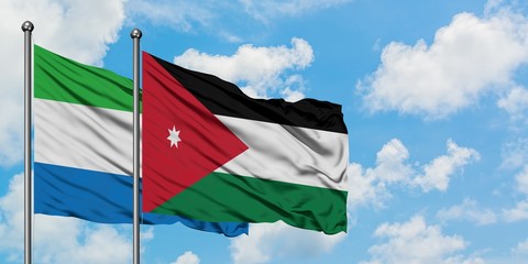 Sierra Leone and Jordan flag waving in the wind against white cloudy blue sky together. Diplomacy concept, international relations.
