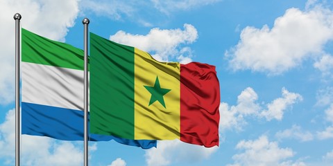 Sierra Leone and Senegal flag waving in the wind against white cloudy blue sky together. Diplomacy concept, international relations.