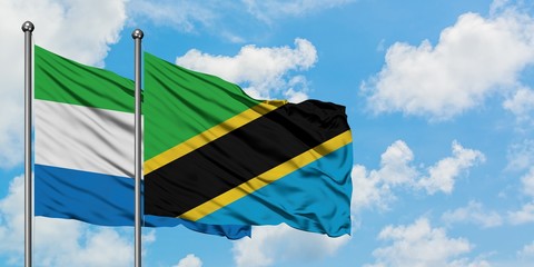 Sierra Leone and Tanzania flag waving in the wind against white cloudy blue sky together. Diplomacy concept, international relations.