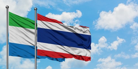 Sierra Leone and Thailand flag waving in the wind against white cloudy blue sky together. Diplomacy concept, international relations.