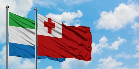 Sierra Leone and Tonga flag waving in the wind against white cloudy blue sky together. Diplomacy concept, international relations.