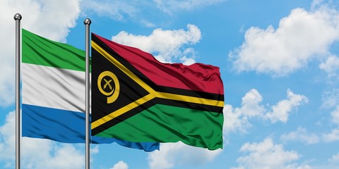 Sierra Leone and Vanuatu flag waving in the wind against white cloudy blue sky together. Diplomacy concept, international relations.