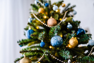 Dressed up Christmas tree. Gold and blue Christmas tree decorations for Christmas.