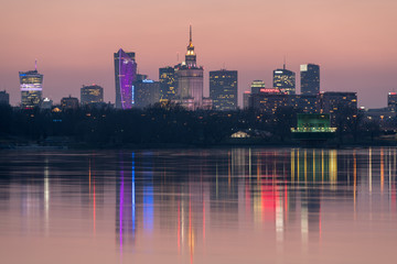 Panorama wieżowców w Warszawie podczas kolorowego zachodu słońca, odbicie w Wiśle, Polska - obrazy, fototapety, plakaty