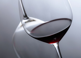 Glass of red wine on a black reflective background.