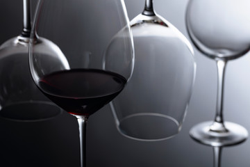 Glass of red wine on a black reflective background.