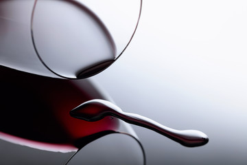 Glass of red wine on a black reflective background.