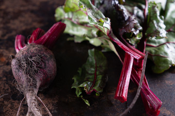 ugly food. Beets and beet leaves on a rusty beautiful metal surface.