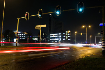 Intersection at night with traffic lights and traffic blurred by motion in Arnhem, Netherlands