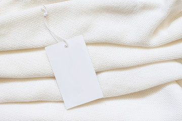 Brand label, blank price tag on white  woolen knitting clothes,  purl stitch pattern