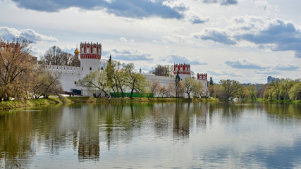 Fototapeta na wymiar Russia. Moscow in the spring. Walls and towers of the Novodevichy Convent beyond the Great Novodevichy Pond