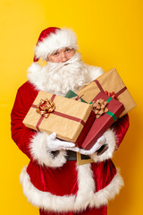 Santa Claus holding bunch of Christmas presents