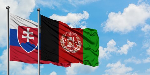 Slovakia and Afghanistan flag waving in the wind against white cloudy blue sky together. Diplomacy concept, international relations.