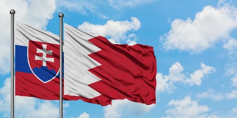 Slovakia and Bahrain flag waving in the wind against white cloudy blue sky together. Diplomacy concept, international relations.