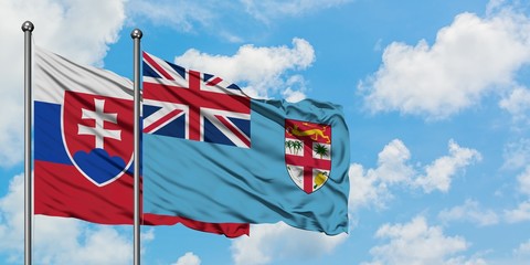 Slovakia and Fiji flag waving in the wind against white cloudy blue sky together. Diplomacy concept, international relations.