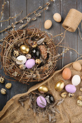Different size Painted colored Eggs And Feathers For Easter on dark wooden background. Boho stile. Alternative decoration.