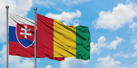 Slovakia and Guinea flag waving in the wind against white cloudy blue sky together. Diplomacy concept, international relations.