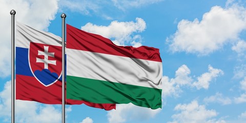 Slovakia and Hungary flag waving in the wind against white cloudy blue sky together. Diplomacy concept, international relations.
