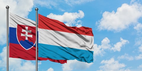 Slovakia and Luxembourg flag waving in the wind against white cloudy blue sky together. Diplomacy concept, international relations.