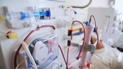 Bloodline tubes with hemodialysis machine in the background. Health care, blood purification,...