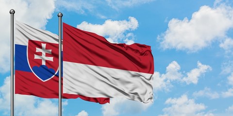 Slovakia and Monaco flag waving in the wind against white cloudy blue sky together. Diplomacy concept, international relations.