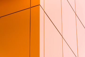 Geometric color elements of the building facade with planes, lines, corners with highlights and reflections for an abstract background and texture of gray, orange, blue colors. Place for text