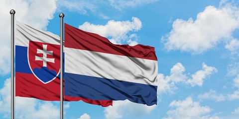 Slovakia and Netherlands flag waving in the wind against white cloudy blue sky together. Diplomacy concept, international relations.