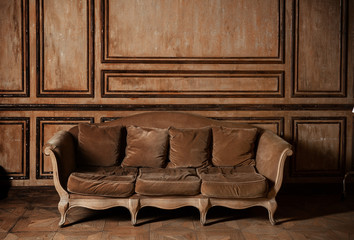An old sofa on the background of vintage wall