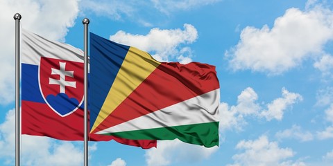 Slovakia and Seychelles flag waving in the wind against white cloudy blue sky together. Diplomacy concept, international relations.