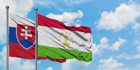 Slovakia and Tajikistan flag waving in the wind against white cloudy blue sky together. Diplomacy concept, international relations.