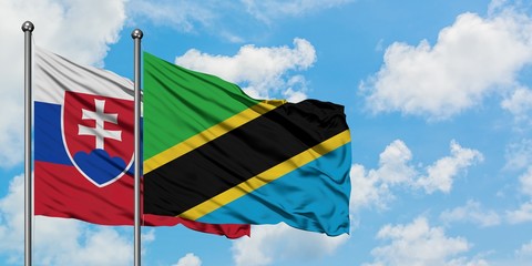 Slovakia and Tanzania flag waving in the wind against white cloudy blue sky together. Diplomacy concept, international relations.