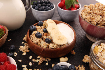 Tasty homemade granola served on table. Healthy breakfast with a bowl of oatmeal with banana, blueberries, strawberries and healthy food for Breakfast
