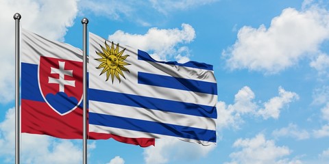 Slovakia and Uruguay flag waving in the wind against white cloudy blue sky together. Diplomacy concept, international relations.