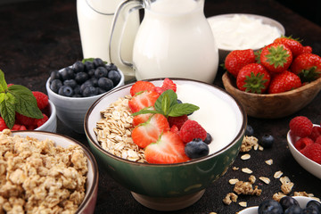 Tasty homemade granola served on table. Healthy breakfast with a bowl of oatmeal with banana, blueberries, strawberries and healthy food for Breakfast