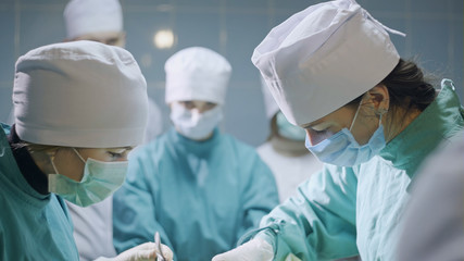 Group of concentrated surgeons wearing uniform in operating room