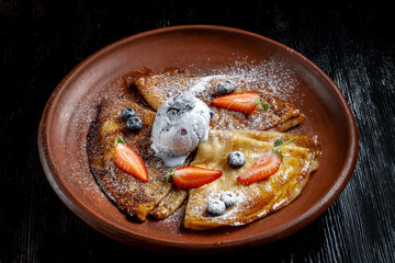 Pancakes with ice cream, with blueberries and strawberries, sprinkled with icing sugar-2.