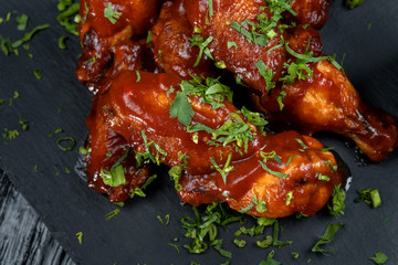 Chicken Wings with tomato barbecue sauce. Sprinkled with dill, onions and parsley.