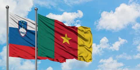 Slovenia and Cameroon flag waving in the wind against white cloudy blue sky together. Diplomacy concept, international relations.