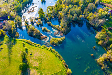 Fototapeta na wymiar Panoramic view of Mreznica river in autumn from drone, green landscape and waterfalls, Croatia, popular touristic destination