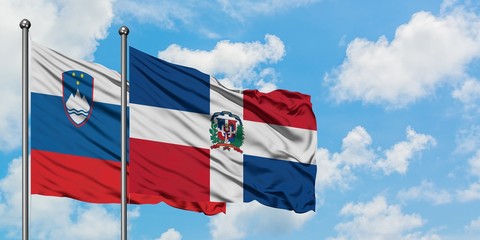 Slovenia and Dominican Republic flag waving in the wind against white cloudy blue sky together. Diplomacy concept, international relations.