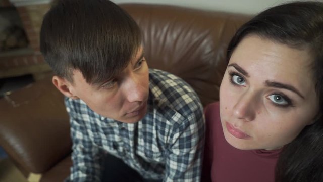 Top view of two scared Caucasian people looking at each other, turning to camera and shaking head yes. Frightened man and woman at psychologist's office. Unusual treatment methods, couples therapy.