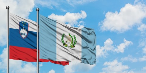 Slovenia and Guatemala flag waving in the wind against white cloudy blue sky together. Diplomacy concept, international relations.
