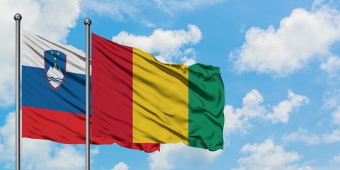 Slovenia and Guinea flag waving in the wind against white cloudy blue sky together. Diplomacy concept, international relations.