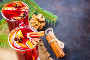 Mulled wine in glass mug with spices. Glasses of mulled wine with cinnamon, anise and fir tree branches. Winter Christmas drink. Top view