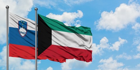 Slovenia and Kuwait flag waving in the wind against white cloudy blue sky together. Diplomacy concept, international relations.