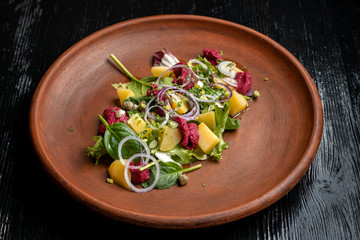 Boiled potatoes with dill and beetroot paste. Sprinkled with onions and capers.