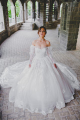 Fototapeta premium Seductive young bride posing on the territory of country hotel
