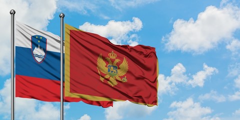 Slovenia and Montenegro flag waving in the wind against white cloudy blue sky together. Diplomacy concept, international relations.