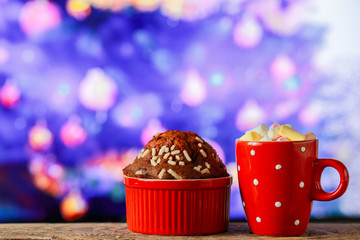 Hot Cocoa with Marshmallows and Christmas Cupcake. Space for text, copywriting. Hot chocolate with marshmallows in a New Year's cup. Christmas Baking Happy New Year 2020